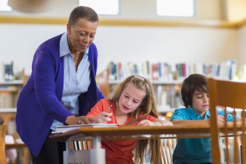 Teacher helping student in classroom