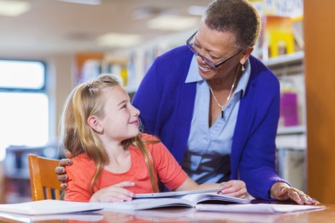 Teacher helping student in library