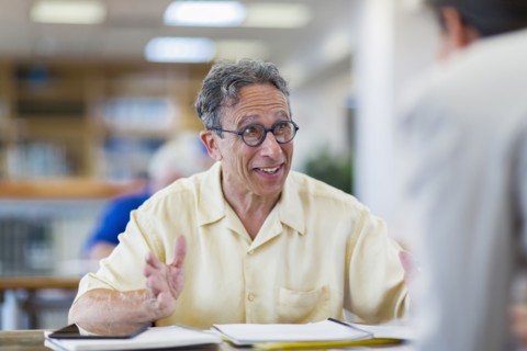 Teacher helping adult student in library