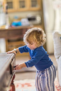 Caucasian baby opening coffee table drawers