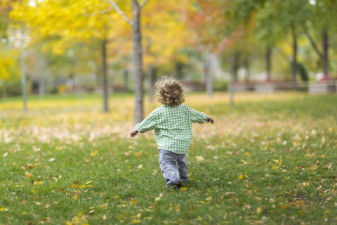Caucasian boy running on grass lawn