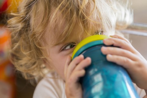 Caucasian baby drinking water from cup