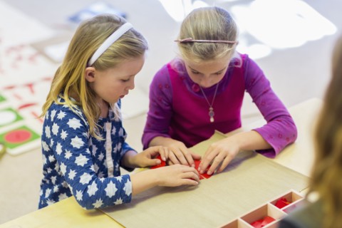 Caucasian girls working together in classroom