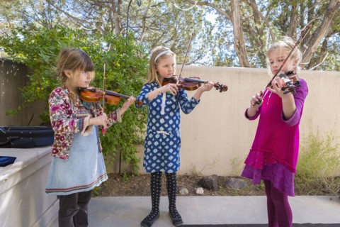 Girls playing violin outdoors