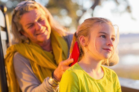Caucasian grandmother brushing hair of granddaughter