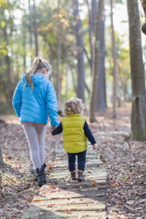 Caucasian brother and sister walking on wooden walkway
