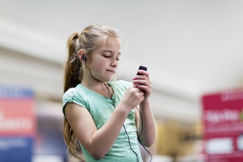 Caucasian girl listening to mp3 player