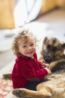 Caucasian baby boy playing with dog on floor