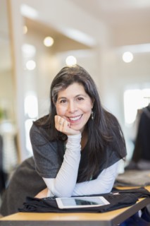 Hispanic small business owner using digital tablet in store