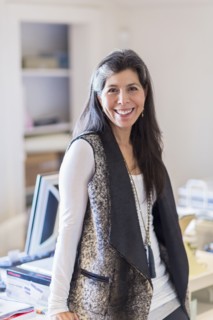 Hispanic businesswoman smiling in office