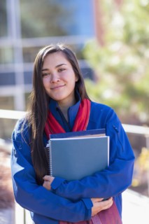 Mixed race student holding books on campus