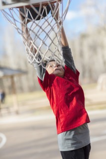 Caucasian boy playing basketball on court