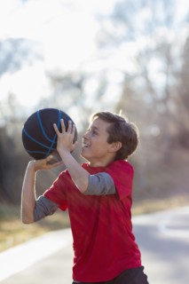 Caucasian boy playing basketball on court