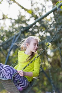 Caucasian girl sitting on swing