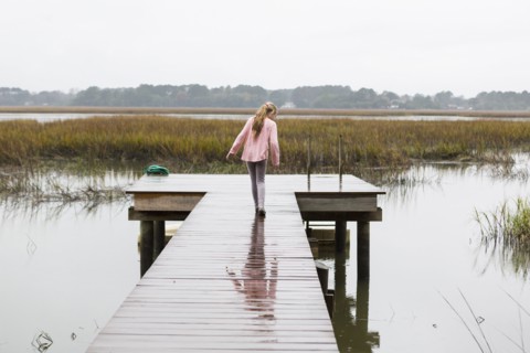 Caucasian girl walking on wooden dock