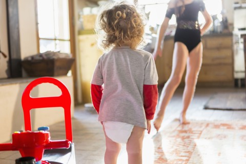 Caucasian baby boy playing with older sister in kitchen