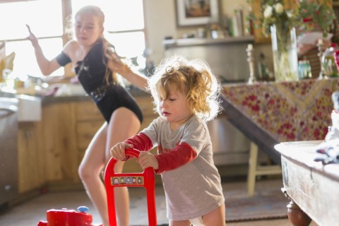 Caucasian baby boy and older sister playing in kitchen