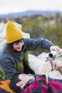 Couple sharing coffee on rock formations