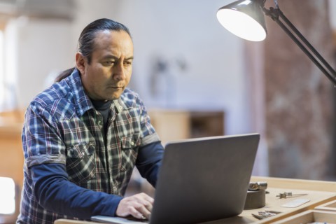 Native American artist using laptop in studio