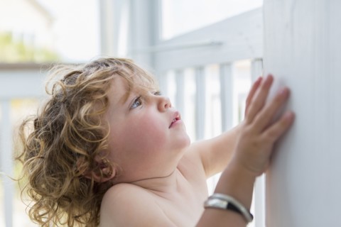 Caucasian baby boy leaning on wall