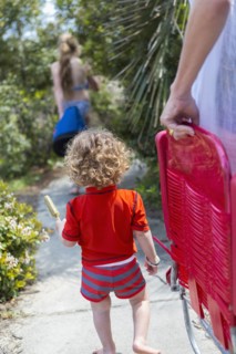 Caucasian family carrying deck chairs to beach