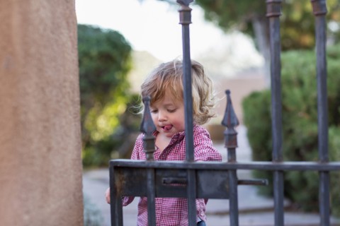 Caucasian baby boy playing at gate