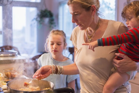 Caucasian mother and children cooking in kitchen