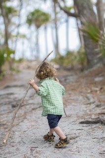 Caucasian baby boy walking on dirt path