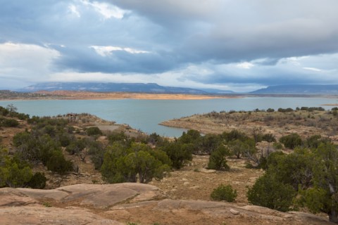 Desert landscape and river under cloudy sky
