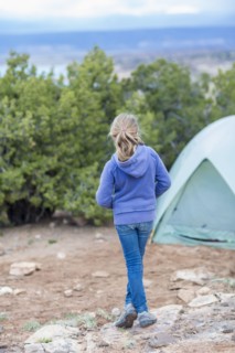 Caucasian girl standing at campsite in desert