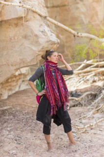 Mixed race hiker exploring desert rock formations barefoot