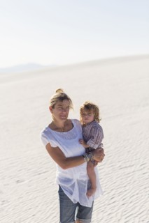 Caucasian mother holding son on desert sand dune