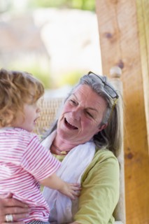 Caucasian woman holding grandson in rocking chair