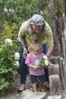 Caucasian woman and grandson picking flowers in garden