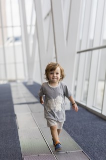 Caucasian baby boy walking in airport