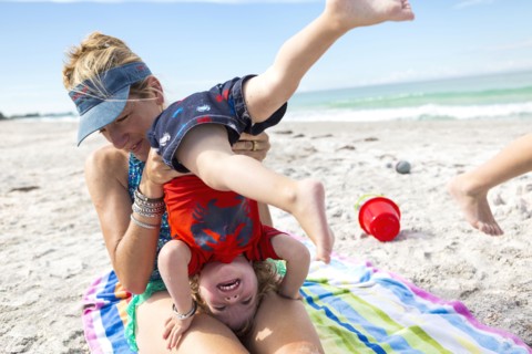 Caucasian family playing on beach