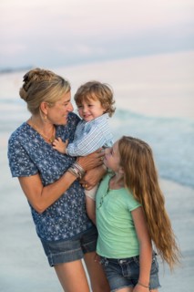 Caucasian mother and children playing on beach