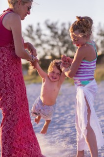 Caucasian mother and children playing on beach