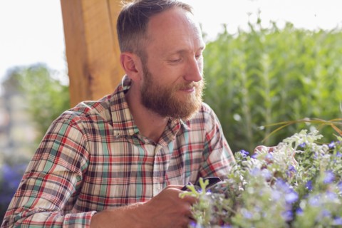 Caucasian man smelling flowers in garden