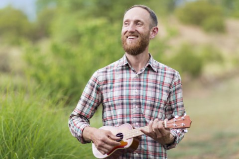 Caucasian man playing ukulele outdoors