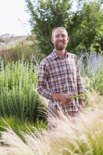 Caucasian man admiring tall plants in garden