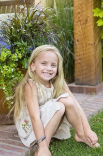 Caucasian girl sitting in backyard