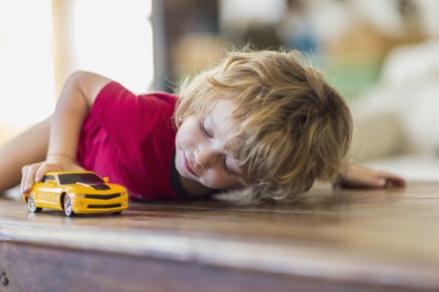 Caucasian boy playing with toy car