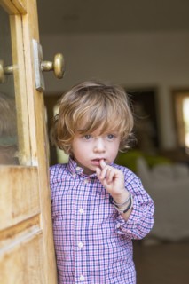 Caucasian boy looking out open door
