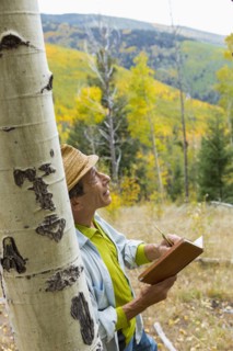Man reading book in autumn forest