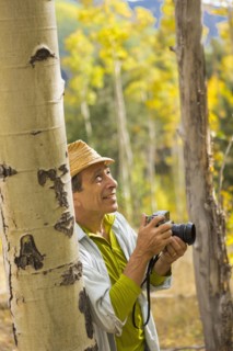 Man photographing with camera in autumn forest