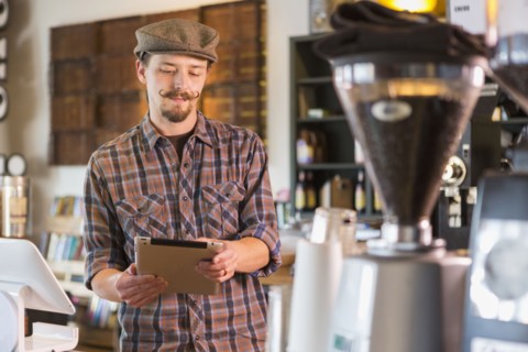 Caucasian man using digital tablet in cafe