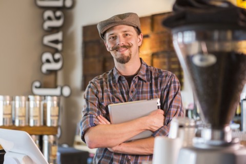 Caucasian barista holding digital tablet in cafe