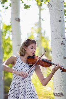 Mixed race musician playing violin outdoors