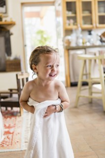 Caucasian boy wrapped in towel